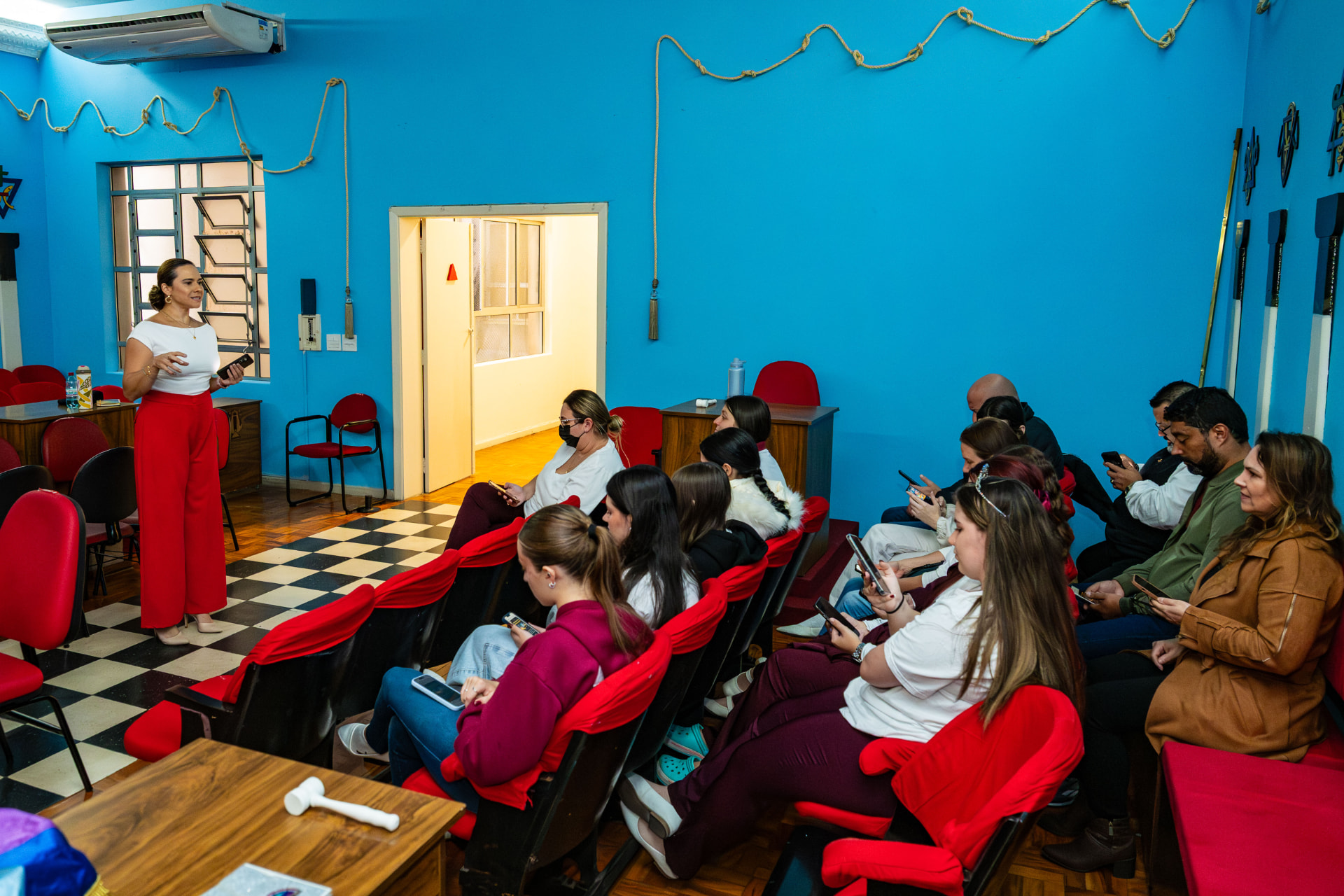 Michely Thomazi falando sobre educação financeira para adolescentes do grupo Meninas do Arco-Íris e seus familiares.